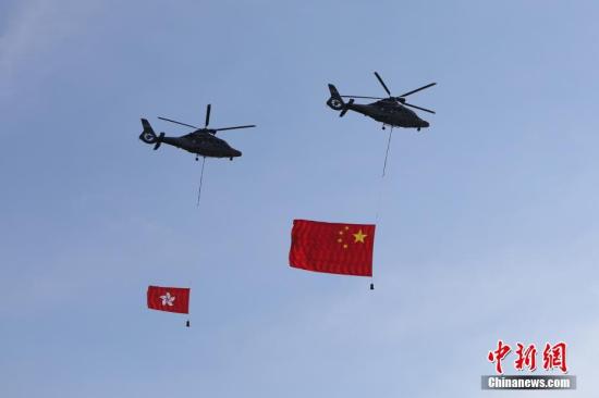 7月1日，香港特区政府在金紫荆广场举行升旗仪式，庆祝香港回归祖国20周年。图为两架分别悬挂中华人民共和国国旗、香港特区区旗的直升机从空中飞过。<a target=_blank  data-cke-saved-href=http://www.chinanews.com/ href=http://www.chinanews.com/>中新社</a>记者 谢光磊 摄