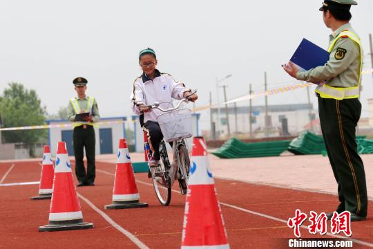 资料图：山东东营东海边防派出所民警为辖区内滨海学校12岁以上学生组织了一场趣味自行车骑行考试。。梁犇 摄